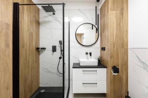 bagno con doccia, lavandino e specchio di Studio Apartment - Odra View&Witolda a Breslavia