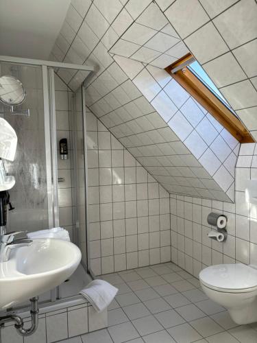 y baño con ducha, lavabo y aseo. en Heitmann`s Gasthof en Kirchlinteln