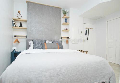 - une chambre avec un grand lit blanc et des étagères dans l'établissement Fort Carre, à Cannes