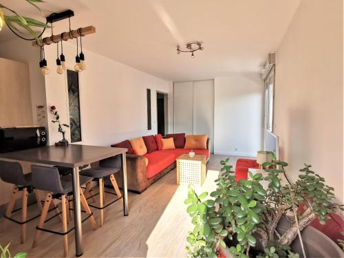 un salon avec un canapé rouge et une table dans l'établissement L'Harmony 3*, 2 Vélos, Vue Montagnes, Terrasse, à Annecy