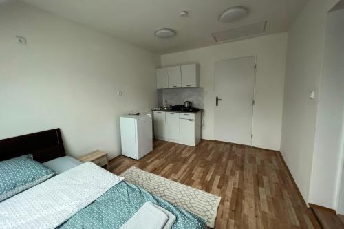 um pequeno quarto com uma cama e uma cozinha em Apartments Gala Abertamy em Abertamy