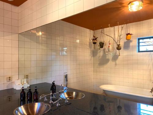 baño con 2 lavabos y una pared de azulejos blancos en Stay Classy, en Otterlo
