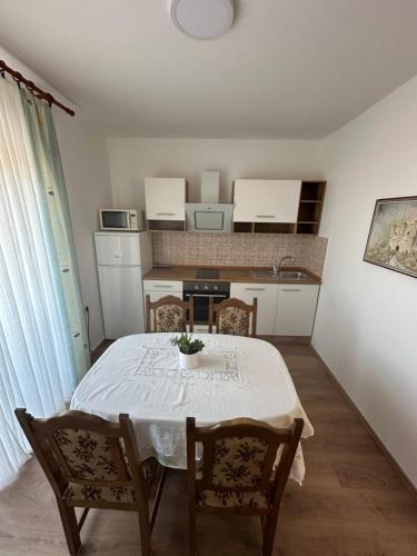 a kitchen with a table and chairs in a room at Apartment & Apartment Studio Deželjin in Senj