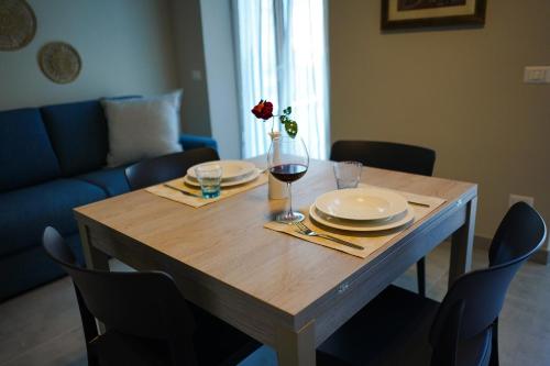 una mesa de madera con platos y una copa de vino en Nausicaa, en Porto SantʼElpidio