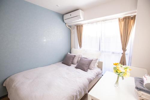 a small bedroom with a bed and a window at 2min walk to Higashi Shinjuku Sta SiEW in Tokyo