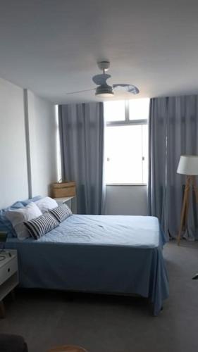 ein Schlafzimmer mit einem blauen Bett und einem Fenster in der Unterkunft Loft Maria Helena I in Vila Velha