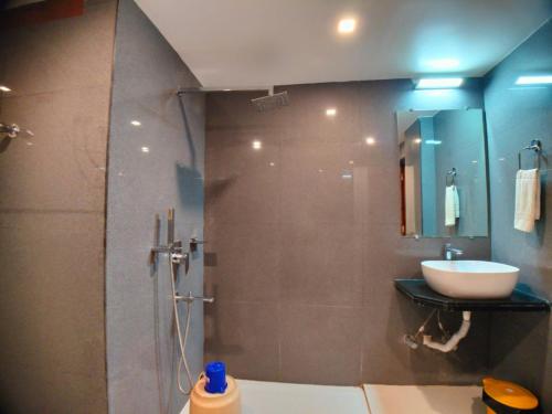 a bathroom with a shower with a sink and a sink at New Gitanjali Hotel, New Digha in Digha