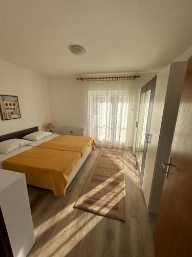 a bedroom with a bed and a large window at Apartment & Apartment Studio Deželjin in Senj