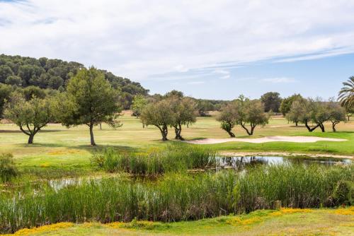 a view of a golf course with trees and a pond at Dos Geckos - Son Parc in Son Parc
