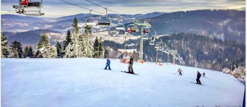 a group of people skiing on a ski lift at Apartamenty Widokowe Na Szczycie in Korbielów