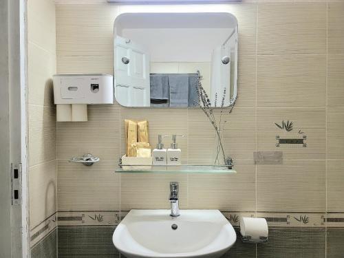 uma casa de banho com um lavatório e um espelho em Tiny homes Ba Đình 02 em Hanói
