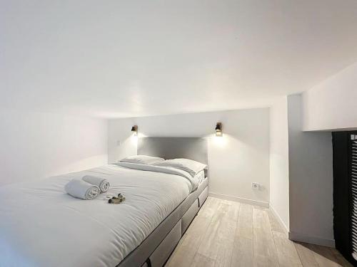 - une chambre blanche avec un grand lit et des draps blancs dans l'établissement Cosy appartement, Villeurbanne Frappaz, à Villeurbanne