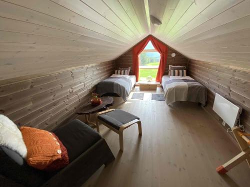 Cette chambre mansardée comprend 4 lits et une fenêtre. dans l'établissement Heinåli Hytta, à Isfjorden