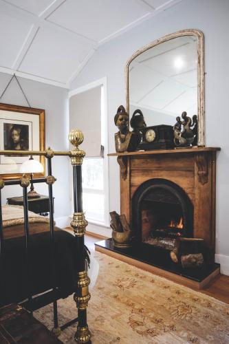 a living room with a fireplace and a mirror at Dingleigh of Sassafras in Sassafras
