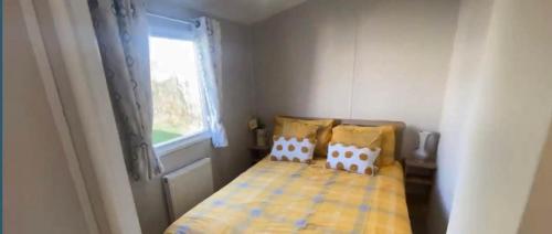 濱海克拉克頓的住宿－Impeccable 3-Bed Caravan in Clacton-on-Sea，一间小卧室,配有床和窗户