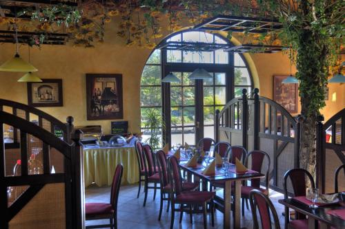 a dining room with tables and chairs and a large window at Hotel Elzet in Tábor