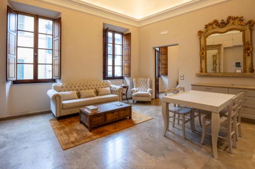 ein Wohnzimmer mit einem Sofa und einem Tisch in der Unterkunft Tuscan Palace - Venturi in Montepulciano