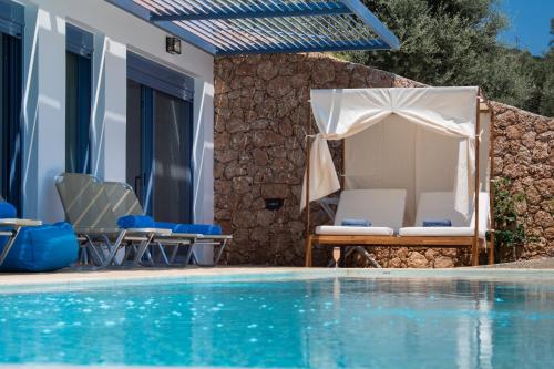 a villa with a swimming pool and a house at Calionas Suites in Vasiliki