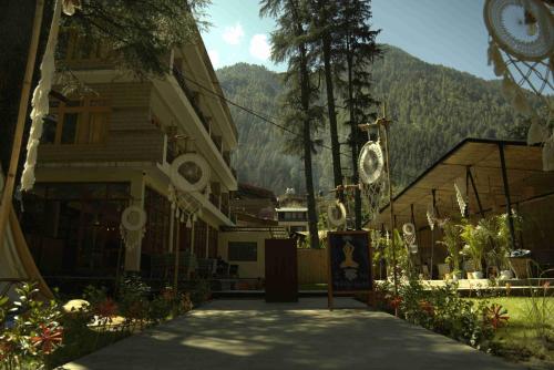 a building with a clock on the side of it at Pinewood by Offlimits Homes in Kasol