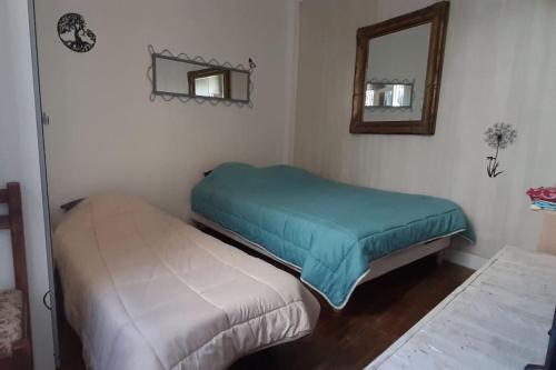 two beds in a room with a mirror at Calme, proche de Paris/ parc des princes in Boulogne-Billancourt