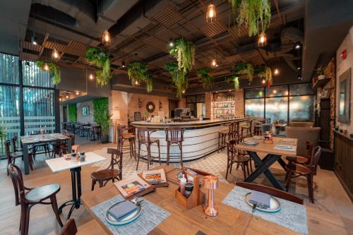 um restaurante com mesas e cadeiras e um bar em The Idle Hotel and Residence - SHA Plus Certified em Pathum Thani