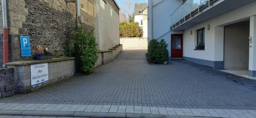 an empty alley with a building and a brick wall at Gästehaus Am Hochsimmer in Ettringen