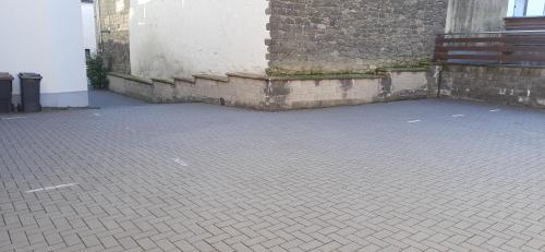a brick courtyard with a brick wall and a building at Gästehaus Am Hochsimmer in Ettringen