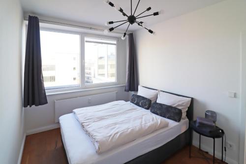 een slaapkamer met een wit bed en een raam bij Air Apartments 14 in Bremen