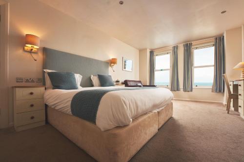 a bedroom with a large bed with a blue headboard at Great Western in Newquay