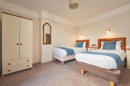 a bedroom with two beds and a dresser at Great Western in Newquay