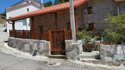 a house with a wooden fence in front of it at Casa da Serra da Estrela in Gonçalo