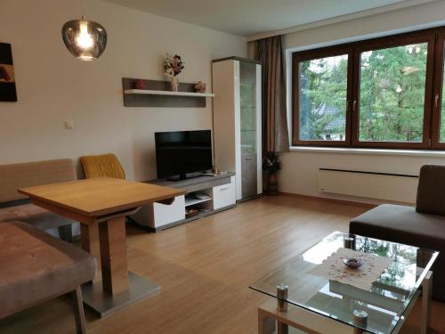 a living room with a table and a television at Haus Gerhild in Velden am Wörthersee