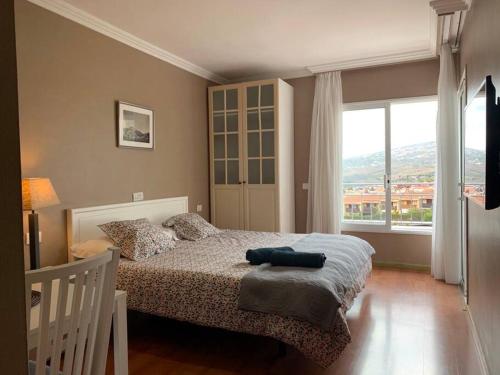 a bedroom with a bed and a large window at D-espacios elevados Quinta in Santa Úrsula