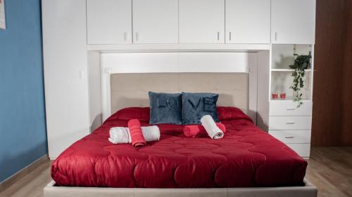 Una cama roja con dos almohadas encima. en Blue Loft - Free Parking en Turín