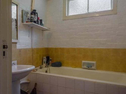 W łazience znajduje się wanna i umywalka. w obiekcie Ondini Cottage w mieście Drakensberg Garden