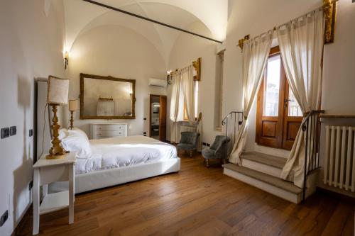 um quarto com uma cama branca e uma janela em Tuscan Palace - Buratti em Montepulciano