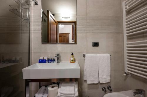 uma casa de banho branca com um lavatório e um espelho em Tuscan Palace - Buratti em Montepulciano