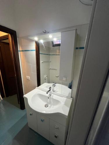 カンニジョネにあるBilocali Residenza Mediterranea Cannigioneのバスルーム(白い洗面台、鏡付)