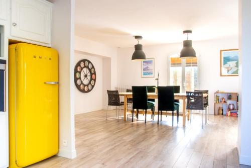 een keuken en eetkamer met een gele koelkast bij La Pergola - Superbe maison au Futuroscope ! in Jaunay-Clan