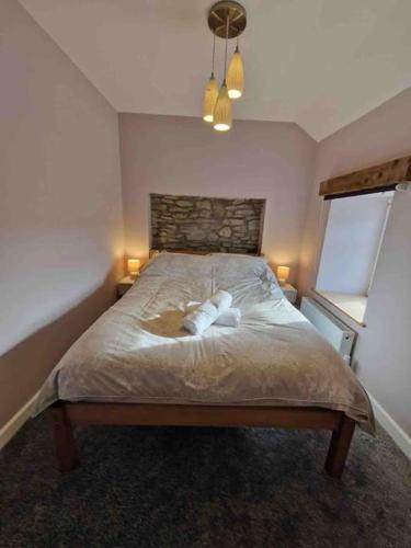 a bedroom with a bed with two towels on it at Riverbank Cottage, Dog Friendly. Swansea, Llanelli in Hendy