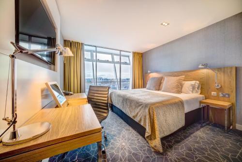 Apex City of Glasgow Hotel في غلاسكو: غرفة في الفندق مع سرير ومكتب