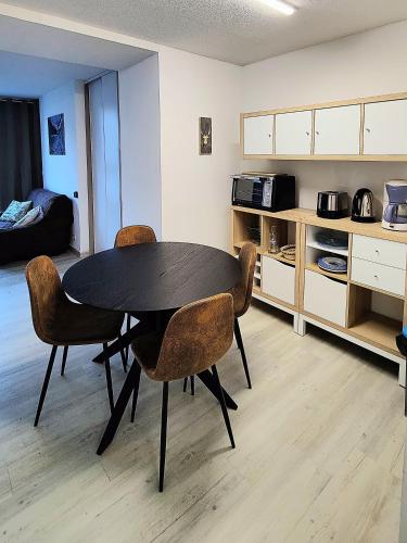 une table de salle à manger et des chaises dans une pièce dans l'établissement CAUTERETS CENTRE AU CALME, à Cauterets