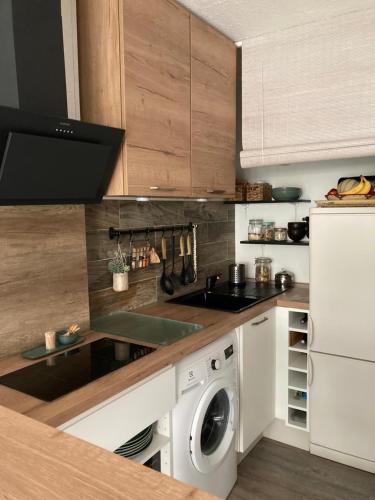 une cuisine avec un évier et une machine à laver dans l'établissement Appartement cocooning à 200m des plages, à Seignosse