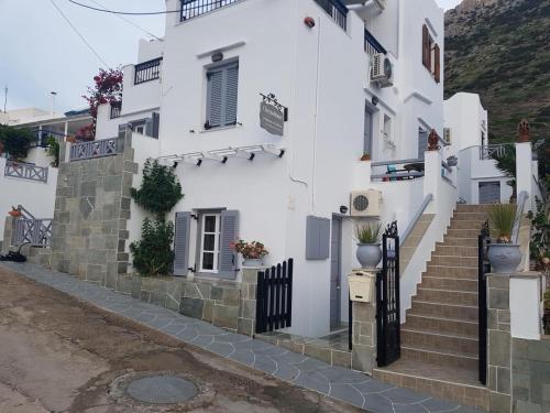 a white house with stairs on a street at Chrysa House in Kamarai