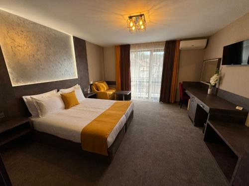 a hotel room with a bed and a television at Стоичковата къща гр. Стрелча in Strelcha