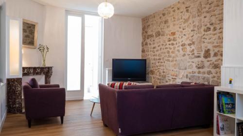 sala de estar con sofá y TV en Le Puit de Lumière - Comfortable T3 in Poitiers!, en Poitiers
