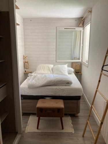 - une chambre avec un lit, une fenêtre et un tabouret dans l'établissement Appartement cocooning à 200m des plages, à Seignosse