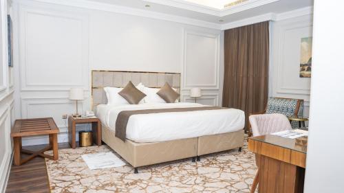 1 dormitorio con 1 cama grande y escritorio en Rose Bark - روز بارك en Hafr Al Batin