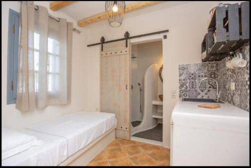 a white bathroom with a shower and a white bench at Ampelos Prokopios in Agios Prokopios