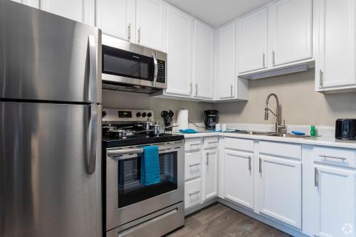 a kitchen with white cabinets and a stainless steel refrigerator at Test Property in Kasnadar